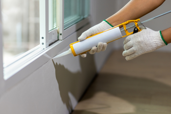 Window Sealing in Livingston, TX 1 Construction worker using silicone sealant caulk the outside window frame