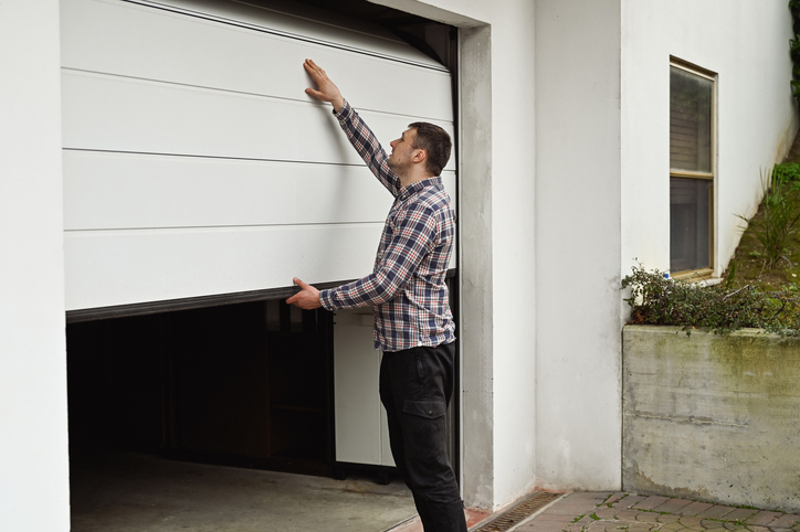 Garage Sealing in Livingston, TX 1 A man is opening a garage door.
